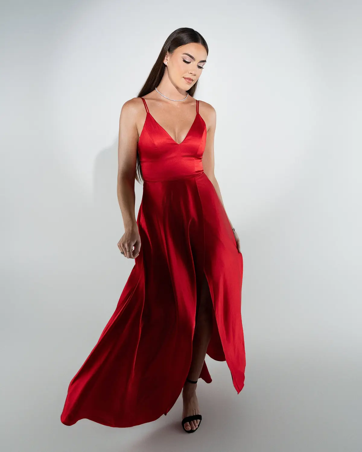 Fashion editorial of a flowing red satin gown shot in-studio in Orlando, Florida by Pottinger Studios