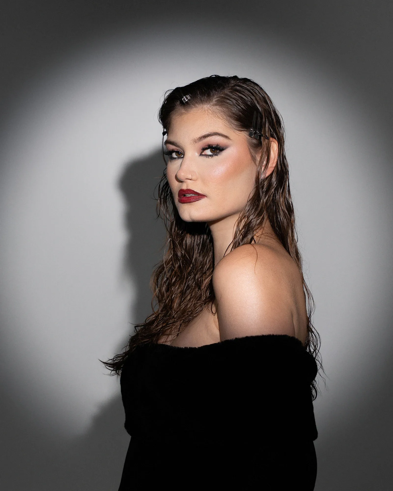Dramatic spotlight portrait with a single hard light in the studio by Pottinger Studios
